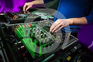 DJ`s hands at the music mixer at a party