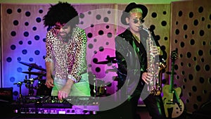 Dj and saxophonist playing music together in house studio