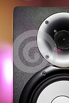 DJ studio monitor speaker with disco lighting background