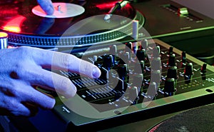 DJ using both hands on a mixer setup