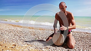 Djembe Drum Player beat rythm on the lonely beach