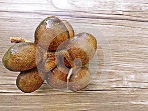 Djenkol beans or Archidendron jiringa seed (Thai Luk Nieng) with wood background