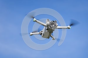 DJI Mini 3 Pro drone in flight in front of a blue sky