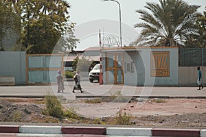 2 Djiboutian women and Djiboutian little girl in local dress walking on the road. Editorial shot in Djibouti