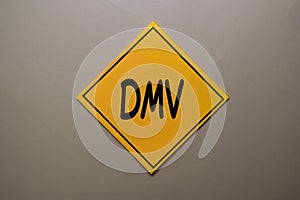 DMV write on a sticky note isolated on office desk