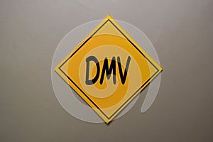 DMV write on a sticky note isolated on office desk photo