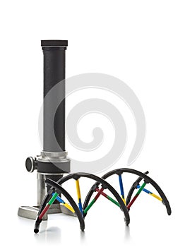 DNA molecule model with old microscope over white background