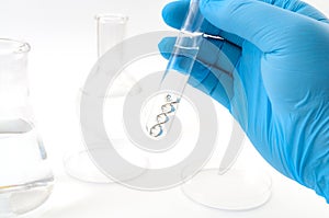 DNA testing, lab experiment and genetic research concept theme with a scientist holding a double helix molecule in a test tube photo