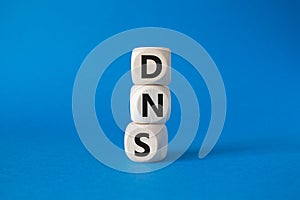 DNS -Domain Name Server - Consumer Price Index symbol. Concept word DNS on wooden cubes. Beautiful blue background. Business and