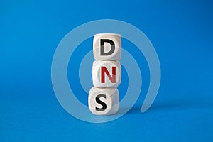 DNS -Domain Name Server - Consumer Price Index symbol. Concept word DNS on wooden cubes. Beautiful blue background. Business and