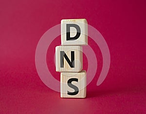 DNS -Domain Name Server - Consumer Price Index symbol. Concept word DNS on wooden cubes. Beautiful red background. Business and