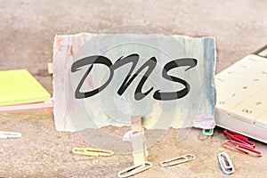 DNS -Domain Name Server text on a piece of paper on the table with a clothespin clamped