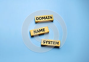 DNS - Domain Name System, acronym technology concept on wooden blocks on blue