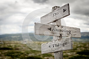 do amazing things text engraved on old wooden signpost outdoors in nature photo