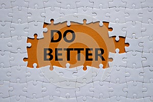 Do better symbol. White puzzle with words Do better. Beautiful orange background. Business and Do better concept. Copy space