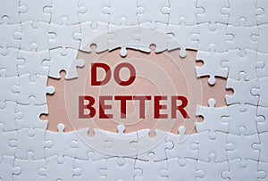 Do better symbol. White puzzle with words Do better. Beautiful pink background. Business and Do better concept. Copy space