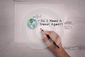 Do I Need A Travel Agent sign with airplane and world art doodle with real hand holding pencil