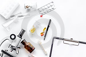 Do medcal tests. Microscope, tablet, pills and test tube on white background top view copyspace