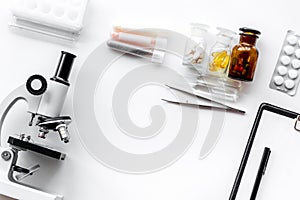 Do medcal tests. Microscope, tablet, pills and test tube on white background top view copyspace