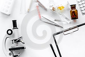 Do medcal tests. Microscope, tablet, pills and test tube on white background top view copyspace