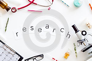 Do medical research with microscope, stethoscope, test-tubes, research copy in lab on white background top view