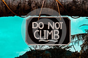 Do not climb sign on coconut palm tree at the beach,thailand.