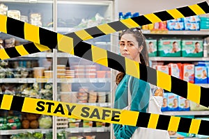 Do not cross.Barrier tape-quarantine,isolation.A young pretty Caucasian woman posing against the background of refrigerators with