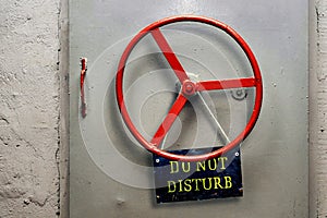 DO NOT DISTURB warning sign plate hanging on a hermetic bomb shelter armored door