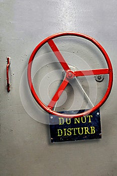 DO NOT DISTURB warning sign plate hanging on a hermetic bomb shelter armored door