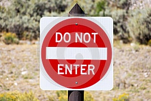 Do Not Enter - traffic sign on wooden post against a blurred landscape