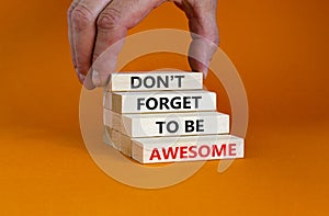 Do not forget awesome symbol. Concept words `Do not forget awesome` on wooden blocks on a beautiful orange background. Businessm