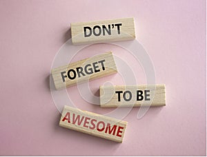 Do not forget to be Awesome symbol. Concept word Do not forget to be Awesome on wooden blocks. Beautiful pink background.