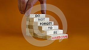 Do not forget to be awesome symbol. Concept words `Do not forget to be awesome` on wooden blocks on a beautiful orange backgroun
