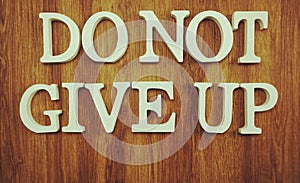 Do Not Give Up word made from wooden cubes with letters alphabet on wooden background