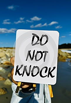 Do not knock text written on white board with nature background. Stock photo.
