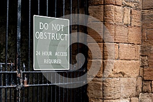 Do Not Obstruct warning sign at Linlithgow Castle in Scotland requiring 24h access to the old metal gate