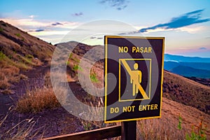 Do not pass singn written in English and Spanish on a hill in Masaya Nicaragua