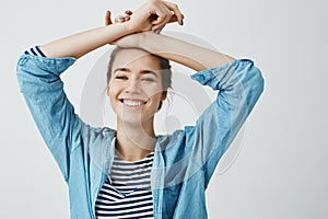 Do not worry be happy. Portrait of gorgeous girlfriend in love, holding crossed arms on forehead, standing in sensual