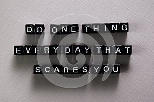 Do one thing everyday that scares you on wooden blocks. Motivation and inspiration concept