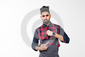 We do ontime. Young confident handyman with beard in blue overall and red t-shirt standing and showing time on his wrist watch