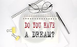 Do You Have A Dream Question on the notebook with pen,clips and glasses