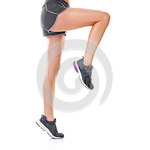 Do you keep your legs smooth. Studio shot of a young woman in shorts and running shoes isolated on white.