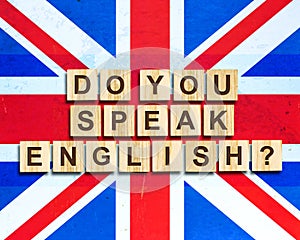 Do you speak English The inscription on the wood blocks, background of the flag of Britain. Concept for school, English language