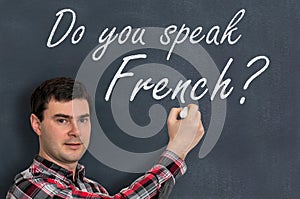 Do you speak French? Man with chalk writing on blackboard