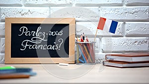 Do you speak French written on board, France flag standing in box, language