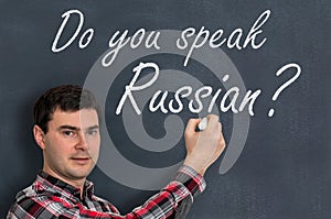 Do you speak Russian? Man with chalk writing on blackboard