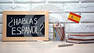 Do you speak Spanish written on board, international flag in box, language
