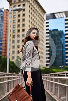 Do you wanna take a walk with me. Cropped portrait of an attractive young woman looking back while walking in the city