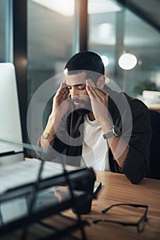 Do you really want to be defeated by the deadline. a young businessman feeling stressed while working late at night in a