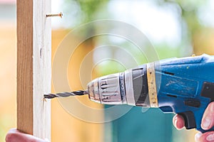 Do it yourself: Home Handyman is using a drilling machine for drilling wood